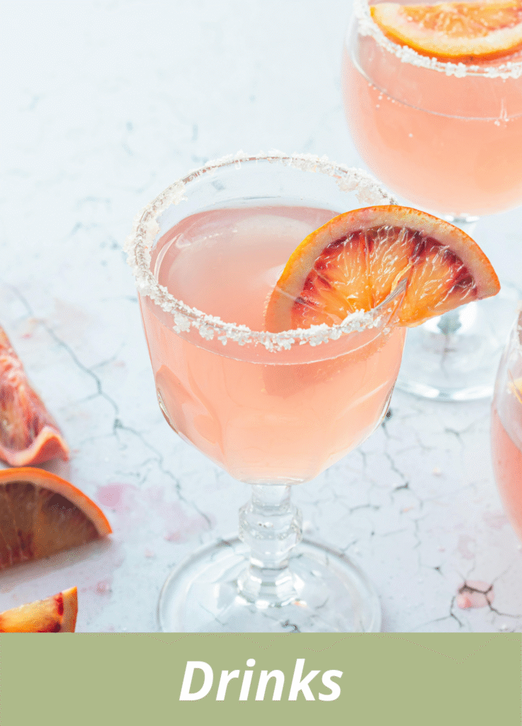 Refreshing pink citrus cocktail served in sugar-rimmed glass with orange slice garnish